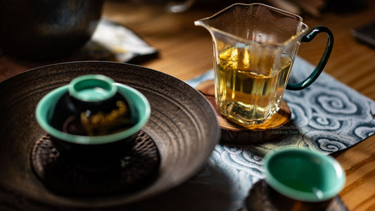 Golden sweet ancient tree tea served in traditional rustic teaware set