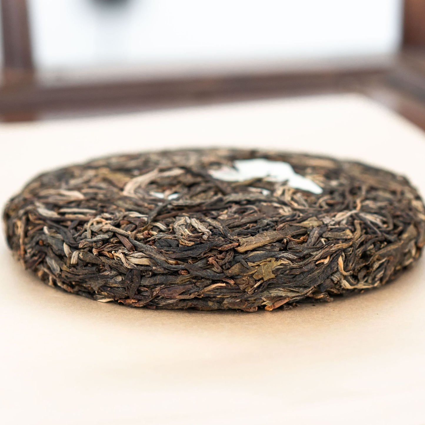 Bingdao Lao Zhai tea cake side profile placed on a tea tray