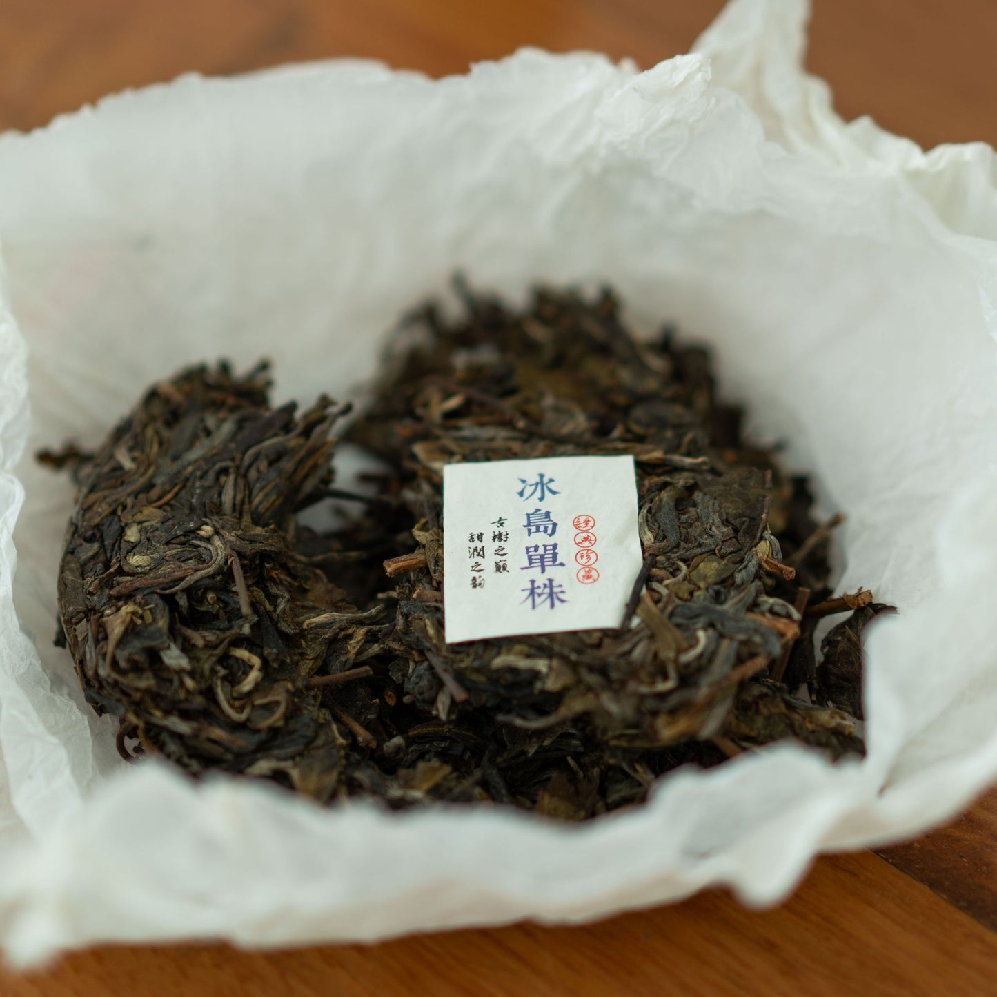 Loose Bingdao Single Bush tea leaves on white wrapping paper