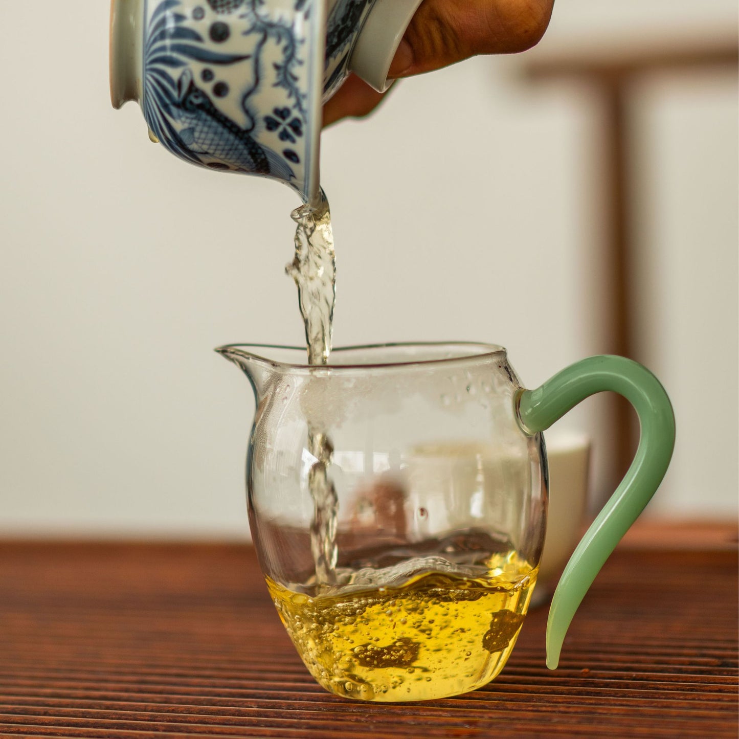 Pouring Bingdao Single Bush tea into a glass pitcher