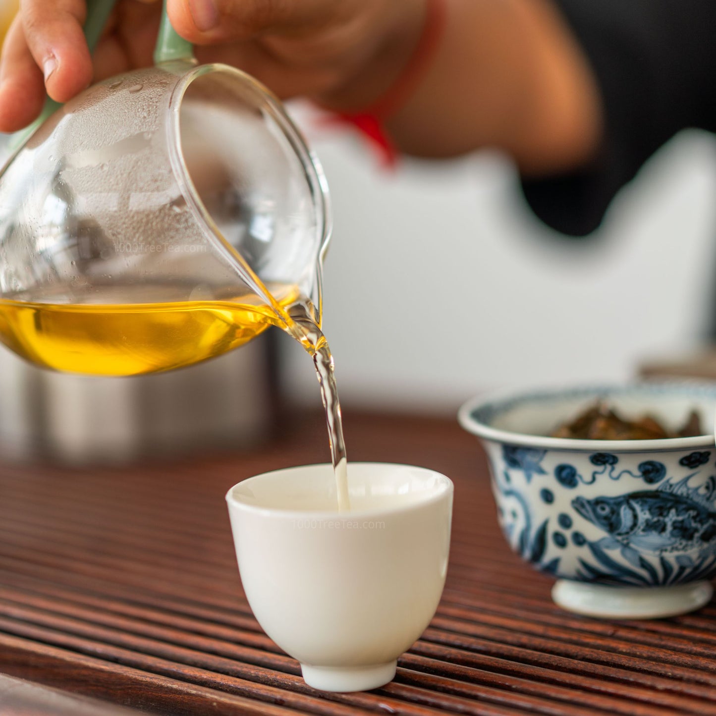 Serving brewed Nanpo Dragon Ball tea into a white ceramic cup