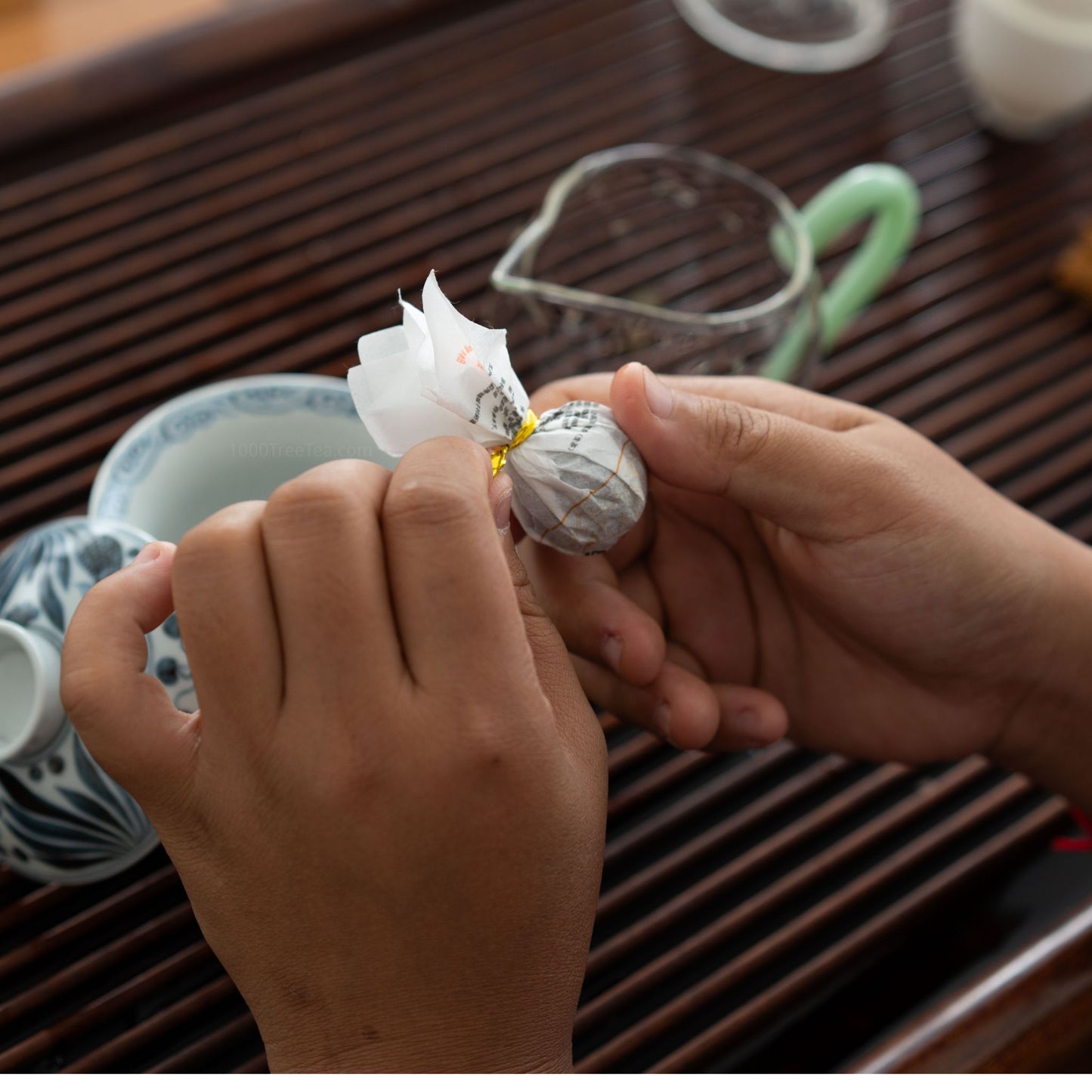 Unwrapping a Nanpo Dragon Ball raw Pu'er tea with hands