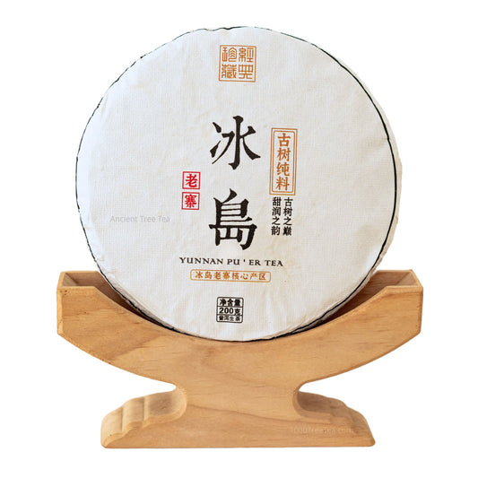 Bingdao Lao Zhai raw Pu'er tea cake displayed on a wooden stand