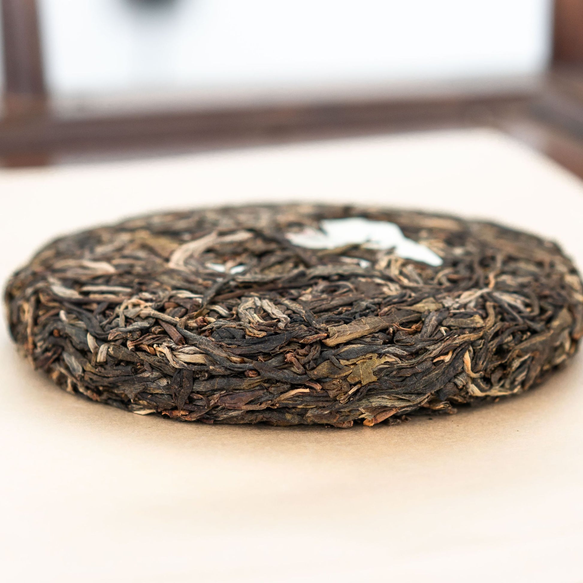 Bingdao Lao Zhai tea cake side profile placed on a tea tray